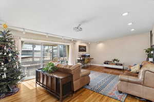 Living room with hardwood / wood-style flooring and rail lighting