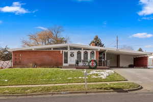 Single story home with a carport and a front lawn