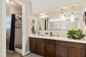 Bathroom with a shower with curtain and vanity