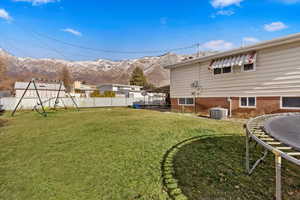 View of yard with a mountain view, cooling unit, and a trampoline