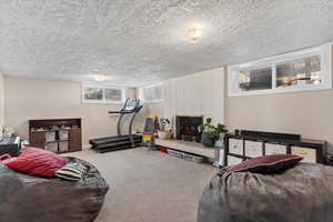 Interior space with a large fireplace, carpet floors, and a textured ceiling