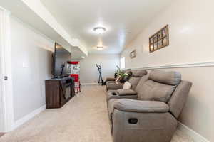 Living area with light colored carpet and baseboards