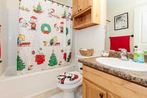 Full bathroom with tile patterned flooring, vanity, toilet, and shower / bath combo