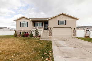 View of front of house featuring a front lawn, a porch, and a garage