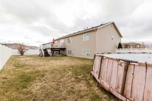 Back of house featuring a yard and a deck