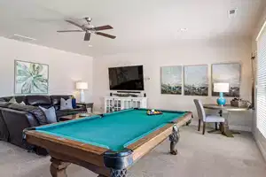 Playroom with carpet floors, ceiling fan, and billiards