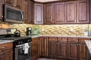 Kitchen featuring light stone countertops, appliances with stainless steel finishes, decorative backsplash, and dark hardwood / wood-style floors