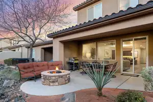 Patio terrace at dusk featuring a fire pit, area for grilling, and a hot tub