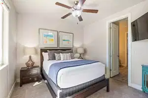 Carpeted bedroom featuring ceiling fan