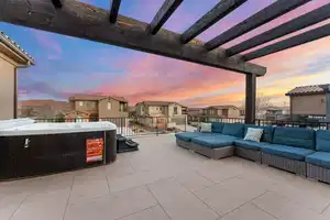 Patio terrace at dusk with outdoor lounge area, a pergola, and a hot tub