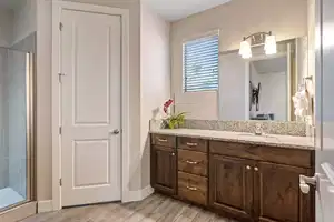 Bathroom featuring hardwood / wood-style floors, vanity, and an enclosed shower