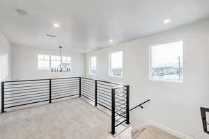 Staircase featuring carpet floors and a chandelier