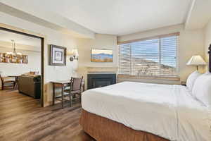 Bedroom with dark hardwood / wood-style floors and a chandelier