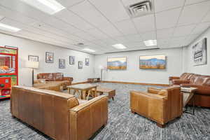 Carpeted living room with a drop ceiling