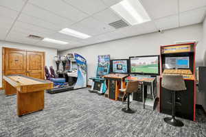 Rec room featuring a drop ceiling and dark carpet