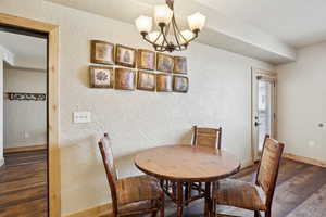 Dining room featuring dark hardwood / wood-style floors and an inviting chandelier