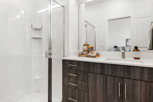 Bathroom with a shower with door and vanity