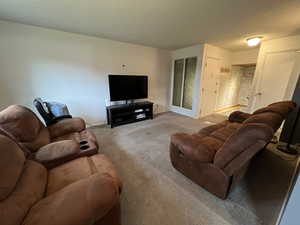 Living room with a textured ceiling and light colored carpet