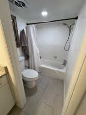 Full bathroom with vanity, shower / tub combo, and toilet