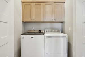 Clothes washing area with cabinets and washer and clothes dryer