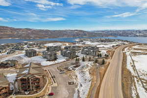 Snowy aerial view featuring a water and mountain view