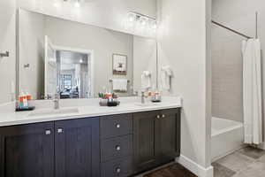 Bathroom featuring vanity and shower / bath combination with curtain