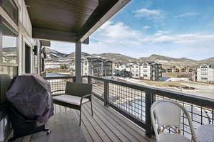 Snow covered back of property featuring a mountain view and area for grilling