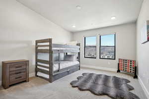 Carpeted bedroom featuring vaulted ceiling