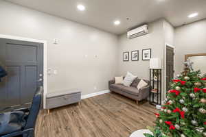 Living room with hardwood / wood-style floors and a wall mounted AC