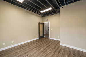 Unfurnished room with a high ceiling and hardwood / wood-style floors