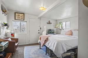 Carpeted bedroom featuring beam ceiling