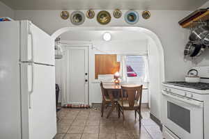 Kitchen with light tile patterned floors and white appliances