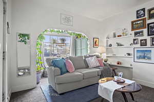 Carpeted living room featuring built in shelves