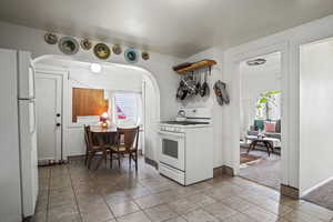 Kitchen featuring light tile patterned floors and white appliances