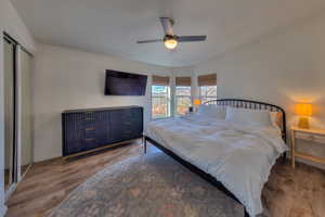 Bedroom featuring a closet, ceiling fan, and dark hardwood / wood-style flooring