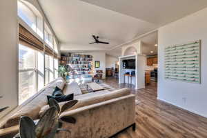 Living room featuring ceiling fan, lofted ceiling, and hardwood / wood-style flooring