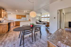 Dining space featuring light wood-type flooring, ceiling fan, lofted ceiling, and sink