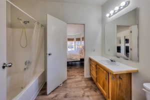 Full bathroom featuring shower / tub combo, vanity, hardwood / wood-style flooring, and toilet