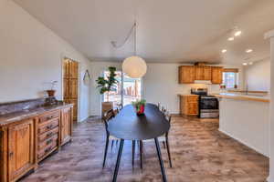 Dining room featuring sink, light hardwood / wood-style floors, and vaulted ceiling