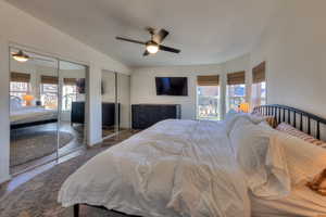 Bedroom featuring ceiling fan, dark hardwood / wood-style floors, multiple closets, and multiple windows