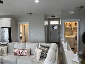Living room with washer and clothes dryer and hardwood / wood-style floors