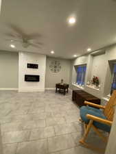 Sitting room with ceiling fan and a large fireplace