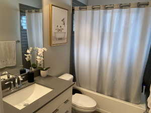 Full bathroom featuring vanity, toilet, and shower / bath combo with shower curtain