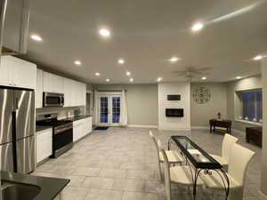 Kitchen featuring white cabinets, appliances with stainless steel finishes, french doors, and ceiling fan