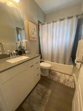 Full bathroom with tile patterned flooring, shower / tub combo with curtain, vanity, and toilet