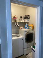 Laundry room featuring washing machine and clothes dryer and dark hardwood / wood-style floors
