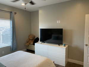 Bedroom with ceiling fan and dark wood-type flooring