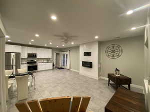 Living room featuring ceiling fan and a fireplace
