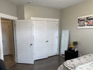 Bedroom with a closet and dark wood-type flooring