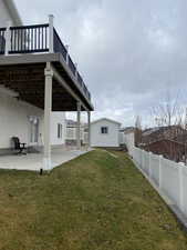 View of yard with an outbuilding, a patio, and a wooden deck